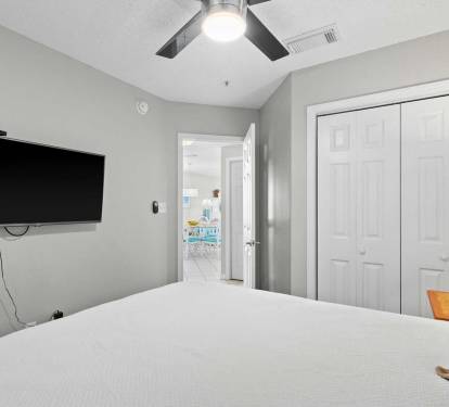 Second bedroom includes a flat-screen TV, spacious closet, and easy access to the main living area.