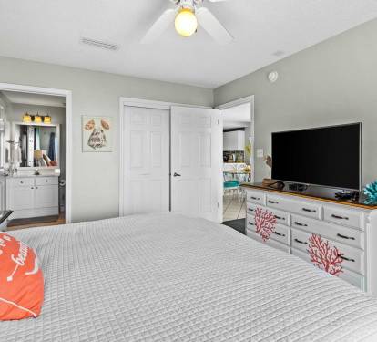 Spacious master bedroom with king bed and a private balcony access, and calming coastal d-cor.