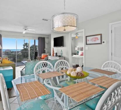 Dining area with seating for six, opening into the living room and balcony views of the Gulf.
