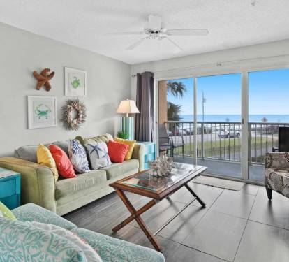 Relax in the living room with large windows showcasing Gulf views just outside.