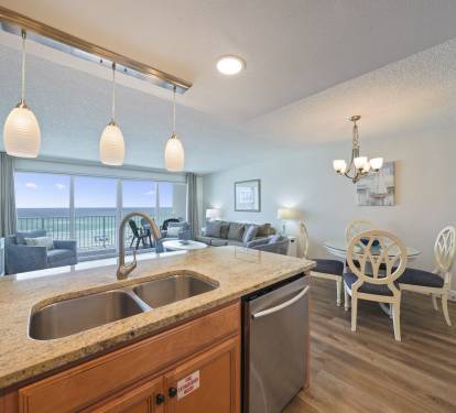 Beachfront condo interior at Cabana Club 307 with updated kitchen, spacious seating area, and panoramic Gulf views from the private balcony.
