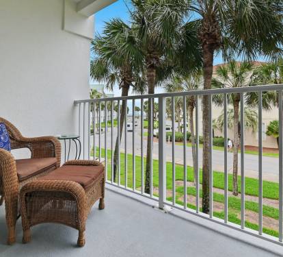 Private balcony with seating and palm tree views at Maravilla 4205, a Miramar Beach vacation rental.