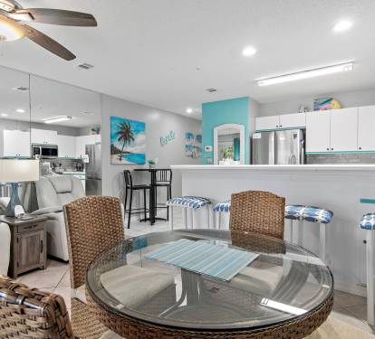 Dining nook with glass table and bar seating at Maravilla 4205, a Miramar Beach vacation rental.
