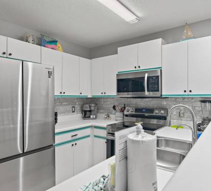 Full kitchen with stainless steel appliances and ample storage at Maravilla 4205.