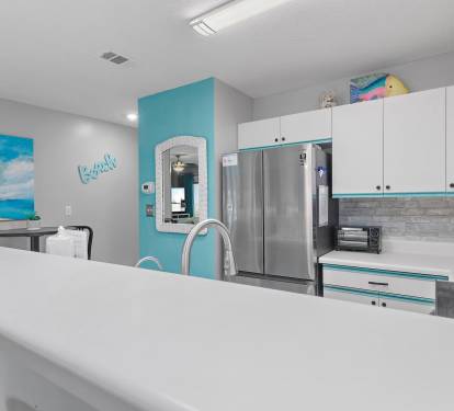Kitchen with stainless appliances and bright coastal accents at Maravilla 4205, a Miramar Beach condo rental.