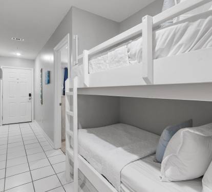 Guest hallway with twin bunk beds and coastal d-cor at Maravilla 4205, a Miramar Beach condo rental.