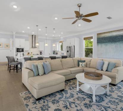 Sectional wraps the room, island kitchen nearby. Designed so whoever cooks stays part of the conversation with your whole group.