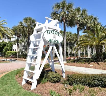 Welcoming Seacrest community entrance with tropical landscaping and palm-lined walkways creating a relaxed coastal setting.