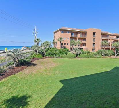 Beautifully maintained lawn and palm-fringed landscaping frame the condo views