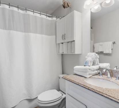 Bright and fresh bathroom with granite vanity, full shower/tub combo.