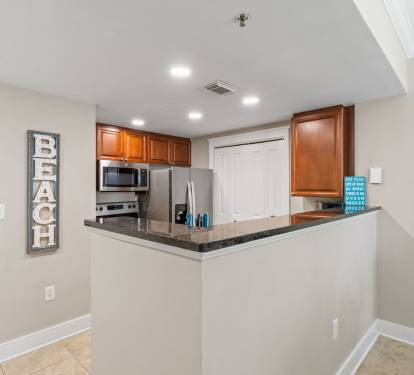 Bright and functional kitchen where you can prepare meals while enjoying a glimpse of the pool and beach from the balcony.