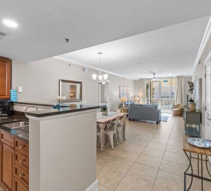 Fully equipped kitchen with modern appliances and balcony views, open to the dining area for easy entertaining.