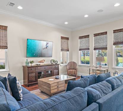 Spacious living room with comfortable seating, natural light and TV.