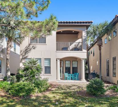 This charming two-story villa features a covered ground-level patio with comfortable seating, perfect for morning coffee or evening relaxation