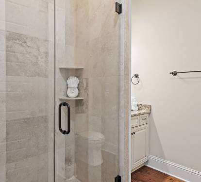Modern tiled shower with glass enclosure and coastal finishes.