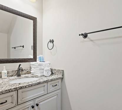Elegant bathroom with granite vanity and soft beach-inspired touches.