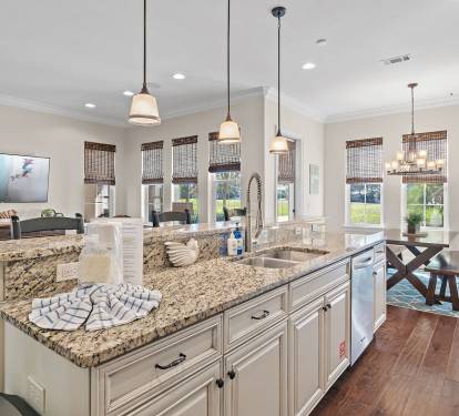 This spacious, light-filled kitchen features expansive granite countertops, stainless steel appliances, and a convenient breakfast bar with seating-perfect for morning coffee or casual meals.