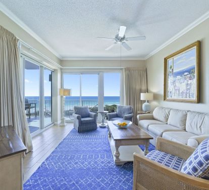 Elegant beachfront living space with floor-to-ceiling windows overlooking the Gulf.