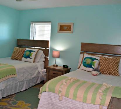 Fantastic beach colors and two double beds in this guest bedroom. There is a flat screen mounted to the wall to the right, promise.