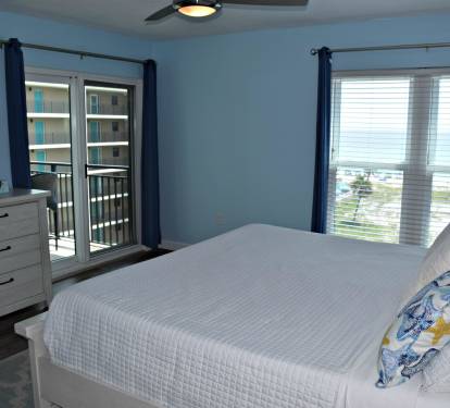 Flat screen television and sliding glass doors to balcony.