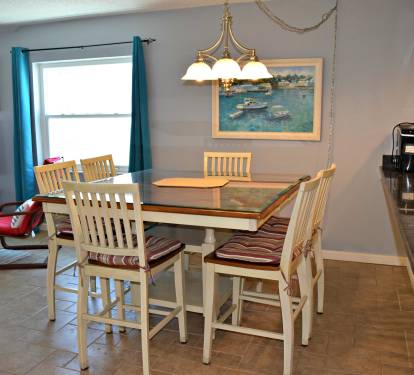 Between kitchen and living room is this large dining table, with a nice tile floor.