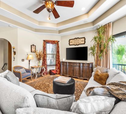 Living area with double tray ceiling & an oversized  70" smart tv