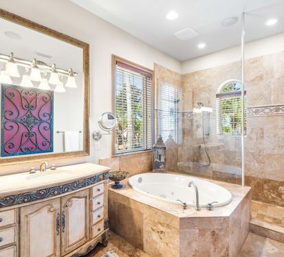 Distinctive vanity, walk-in frameless shower, whirlpool bathtub, & separate water closet in this primary bathroom.