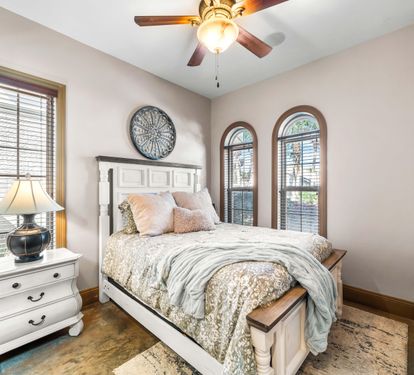 Experience comfort and privacy in this 1st floor bedroom with a queen bed, double arched windows & an en suite bathroom.