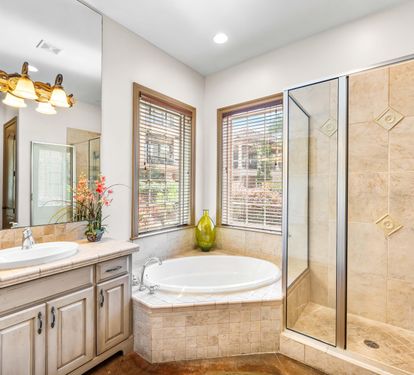 This shared bathroom full bathroom has a separate walk-in shower with the soaking tub and a private water closet.