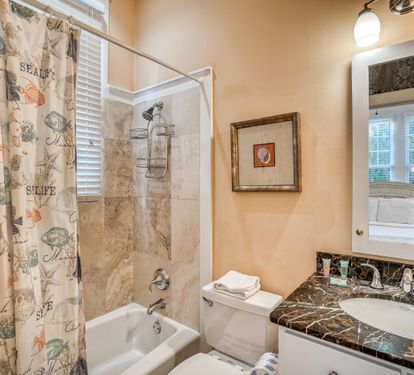 Convenient bathtub with shower in this peachy en suite bathroom.