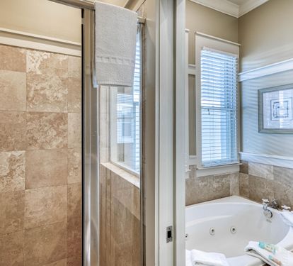 Travertine walk-in shower in the primary ensuite.