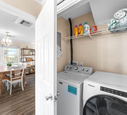 Washer and Dryer with laundry detergent and dryer sheets. Green and white beach towels for your use.