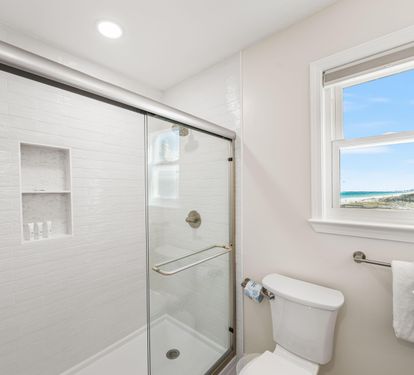 Walk-in shower and another view of the coastline from this primary ensuite bathroom.