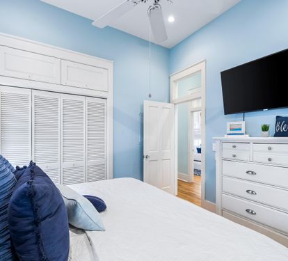King bedroom with an en suite bathroom, large closet, ceiling  fan, and a 50" Smart TV.  .