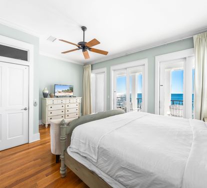 3rd floor primary bedroom with king bed, balcony with seating, tv with cable, & ensuite bathroom.