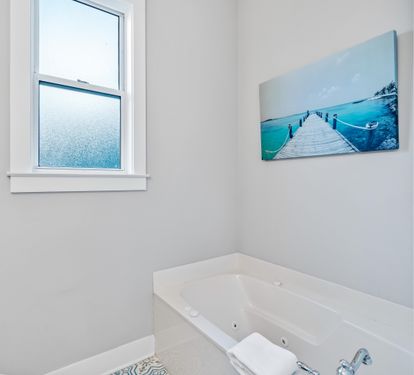 2nd floor ensuite bathroom for the primary king bedroom with double vanities, separate walk-in shower, & soaking bathtub.