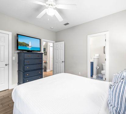 First floor bedroom with a queen bed,42" tv, large walk-in closet, additional door out to the front porch, and a full bathroom.