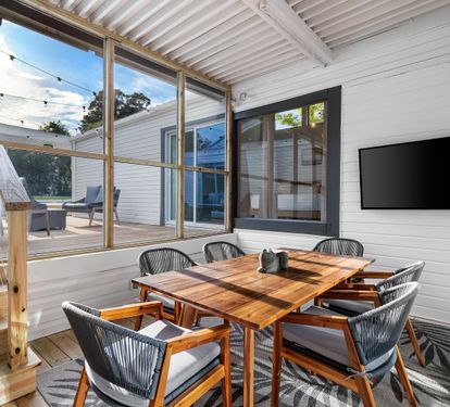 Just off the Kitchen is Another Dining Area Seating on A Covered Screened in Patio with a 58" Smart TV.
