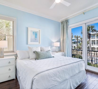 Second Floor Bedroom with king bed, ensuite bathroom, and balcony overlooking the Frangista Beach community.