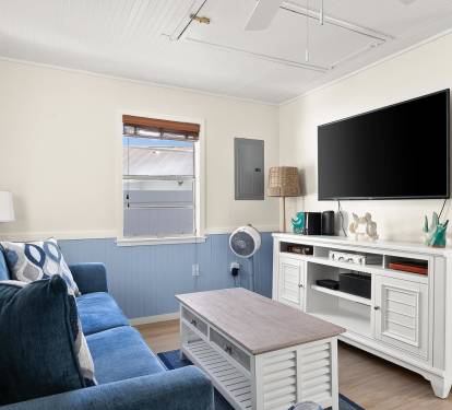 Sunlight fills this inviting living space with soft coastal hues, comfortable seating, and casual furnishings ideal for unwinding after a day by the shore.