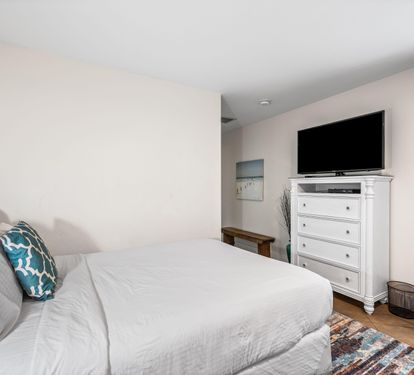 East end of Seabreeze has a 2nd bedroom with 2 queen beds & adjacent full bathroom with a walk-in shower.   TV located above the chest of drawers