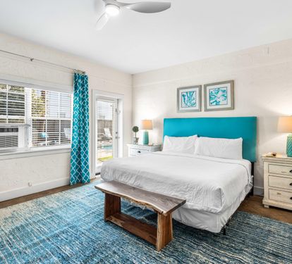 3rd Bedroom is the primary suite on the east end with a king bed, 45" TV,  walk-in closet, ensuite full bathroom with a bathtub/shower combination, and views of the pool area & door leading out to the pool.  (safety alarm on door)