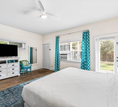 3rd Bedroom is the primary suite on the east end with a king bed, 45" TV,  walk-in closet, ensuite full bathroom with a bathtub/shower combination, and views of the pool area & door leading out to the pool.  (safety alarm on door)