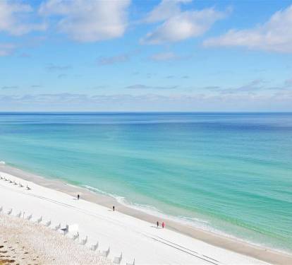 Pristine white sand beach with crystal-clear turquoise waters stretches endlessly along the Gulf Coast.