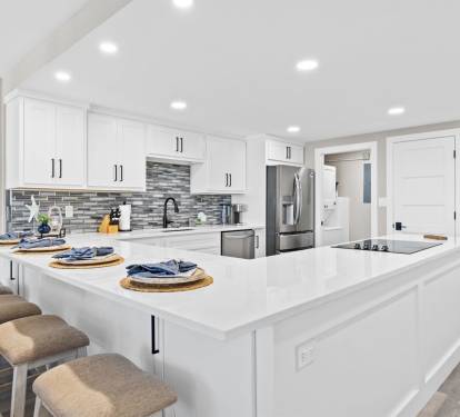 Your modern kitchen features pristine white cabinetry, gleaming quartz countertops, and premium stainless steel appliances for effortless meal preparation.