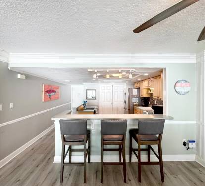Gather around your breakfast bar where the open-concept design seamlessly connects to the fully-equipped kitchen, perfect for morning coffee and evening conversations.