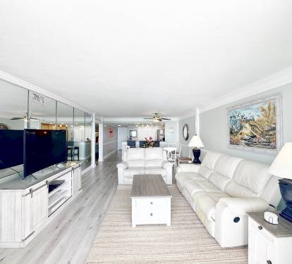 Sink into plush white leather seating while enjoying your open-concept living space with modern coastal touches and ocean views.