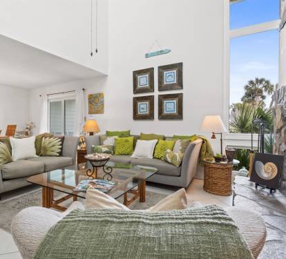 Unwind in your elegant living room with comfortable seating, warm fireplace, and stunning mountain views through floor-to-ceiling windows.