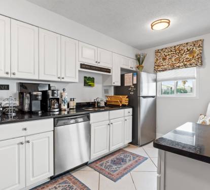 Your fully-equipped kitchen awaits with granite counters, stainless appliances, and a charming coffee corner for brewing your perfect morning cup.