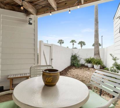 Your private patio invites peaceful mornings with coffee under string lights, surrounded by tropical palms and coastal charm.